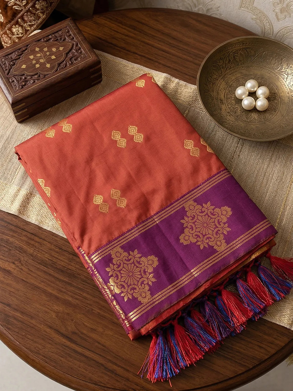 Tarani orange soft silk saree pallu view with zari tassels and jacquard weaving closeup