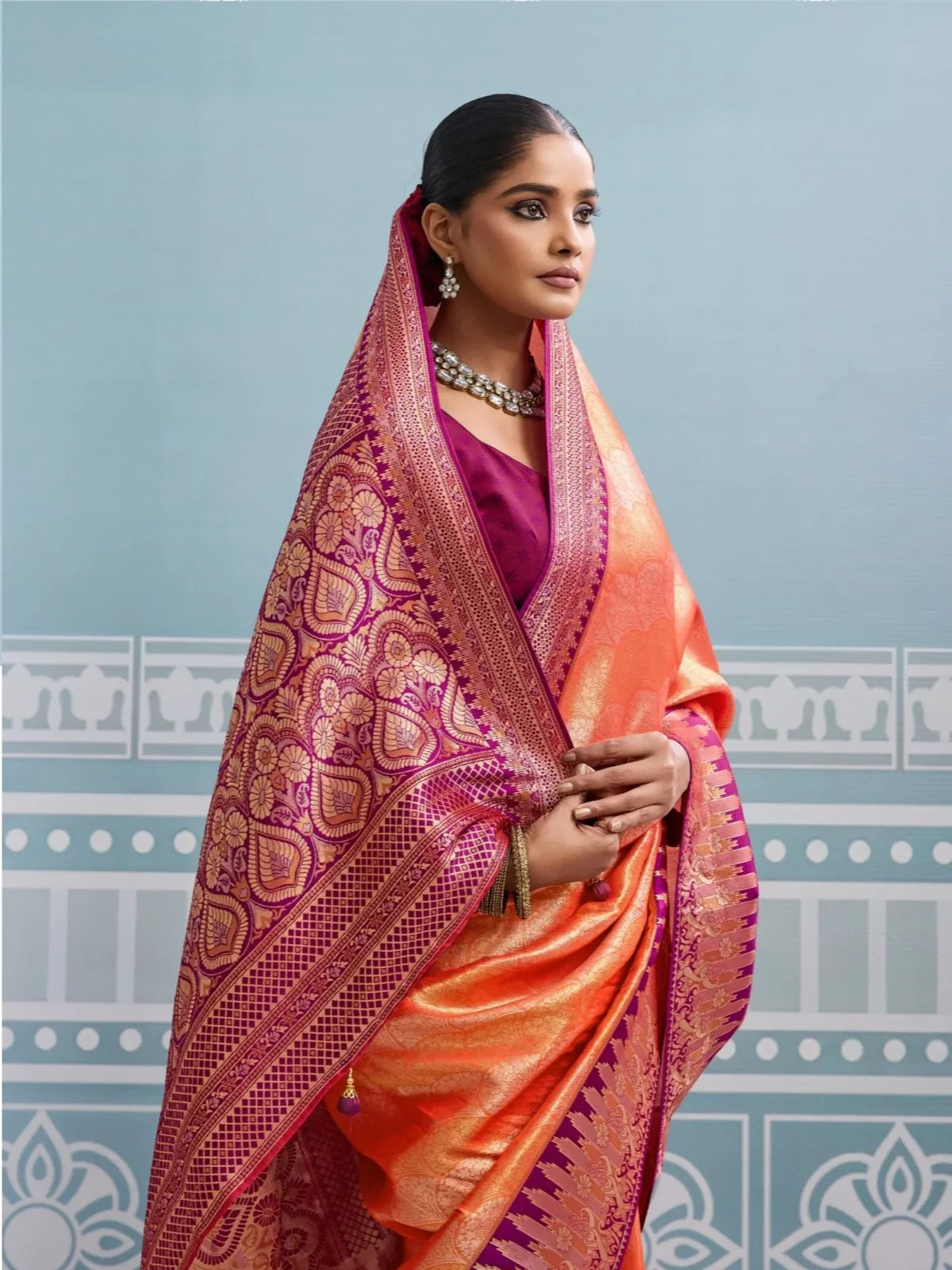 Tarani orange silk saree side view showing broad zari border and blouse