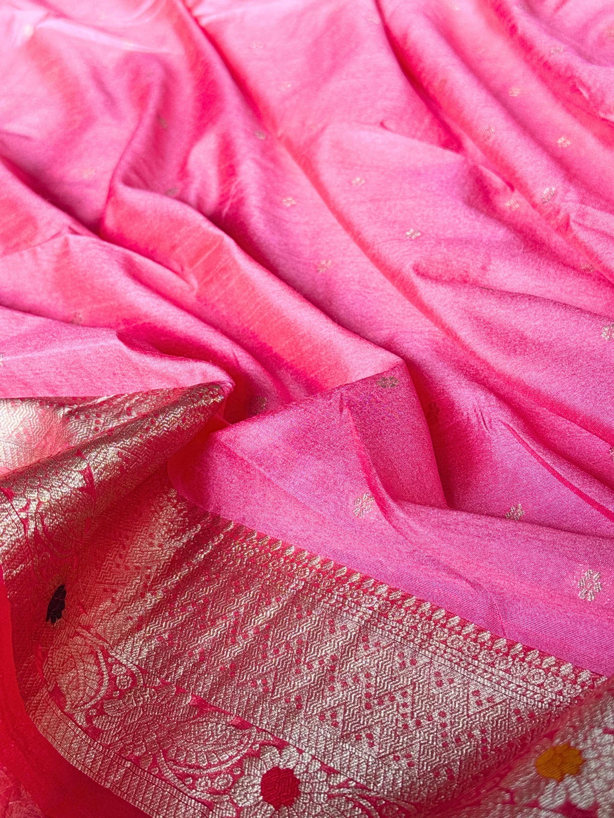 Tarani pink silk saree fabric closeup with detailed woven texture and zari border
