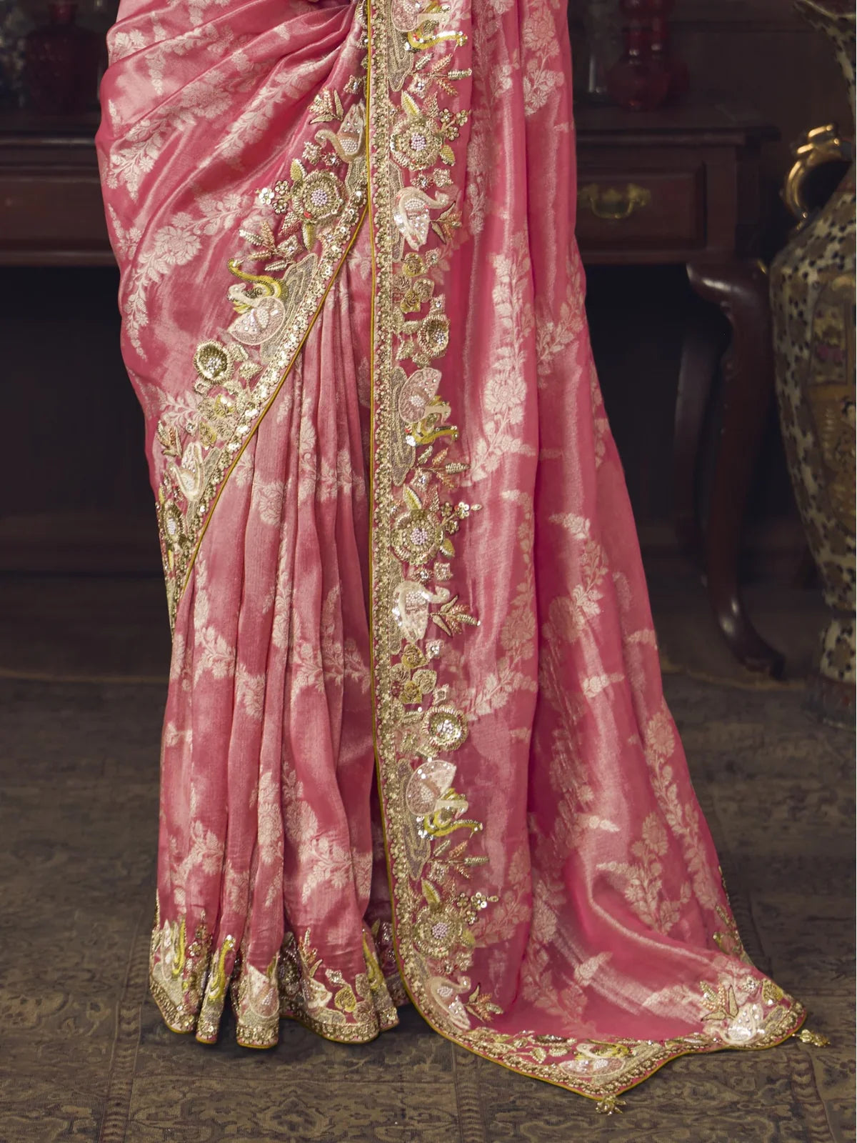 Tarani closeup view of floral zari embroidery work and fabric detailing on pink silk saree