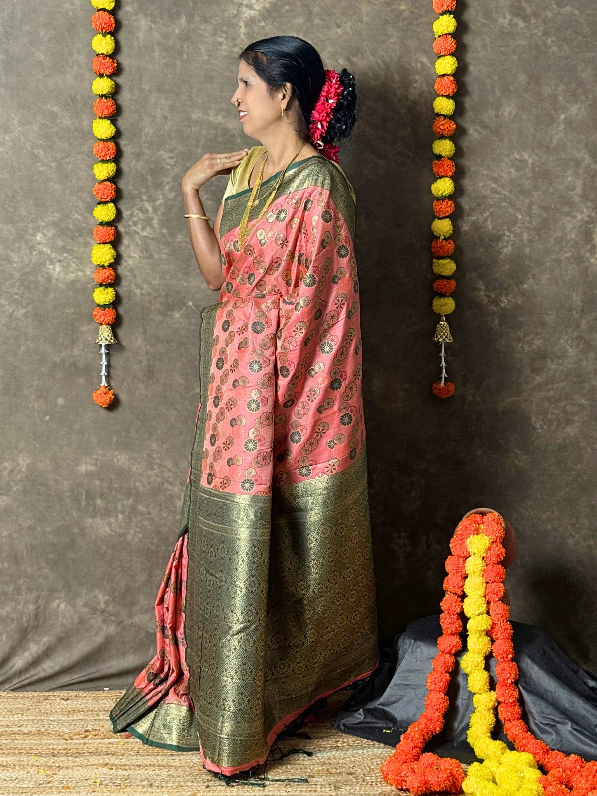 Tarani pink silk saree side view with golden woven motifs for festive occasions