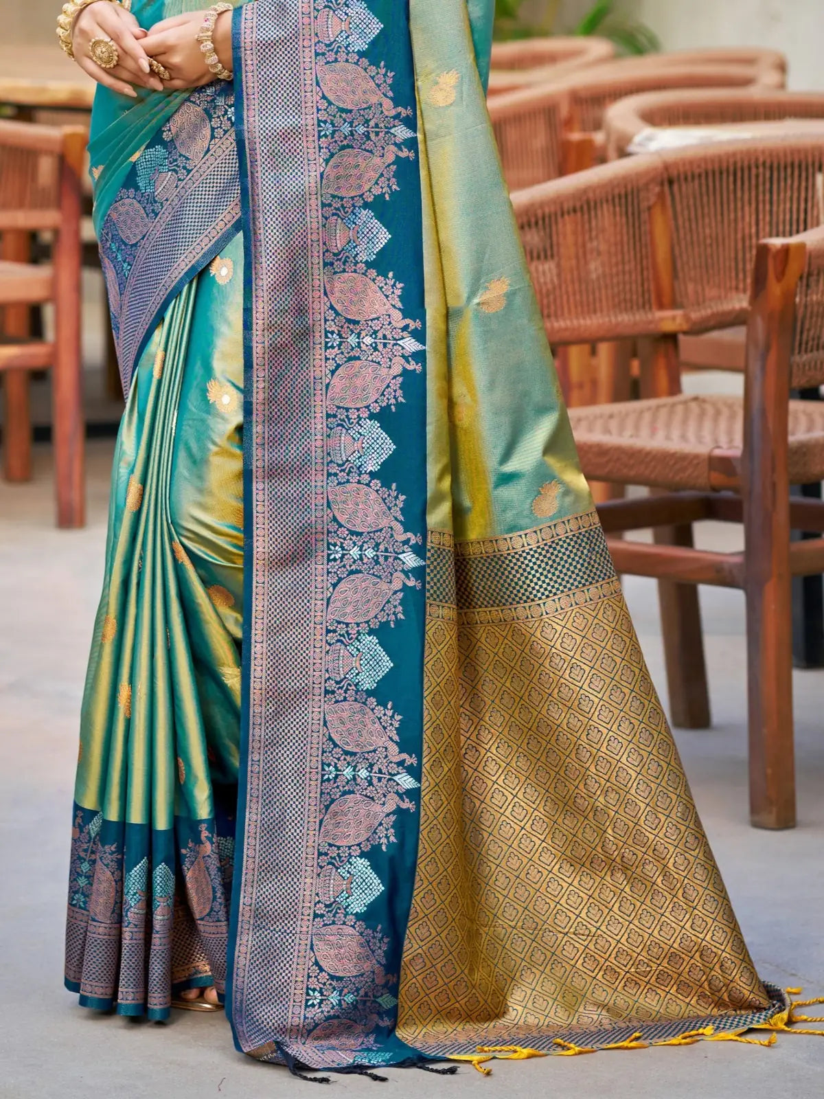 Tarani teal soft silk saree pallu closeup with zari woven border detailing and tassels