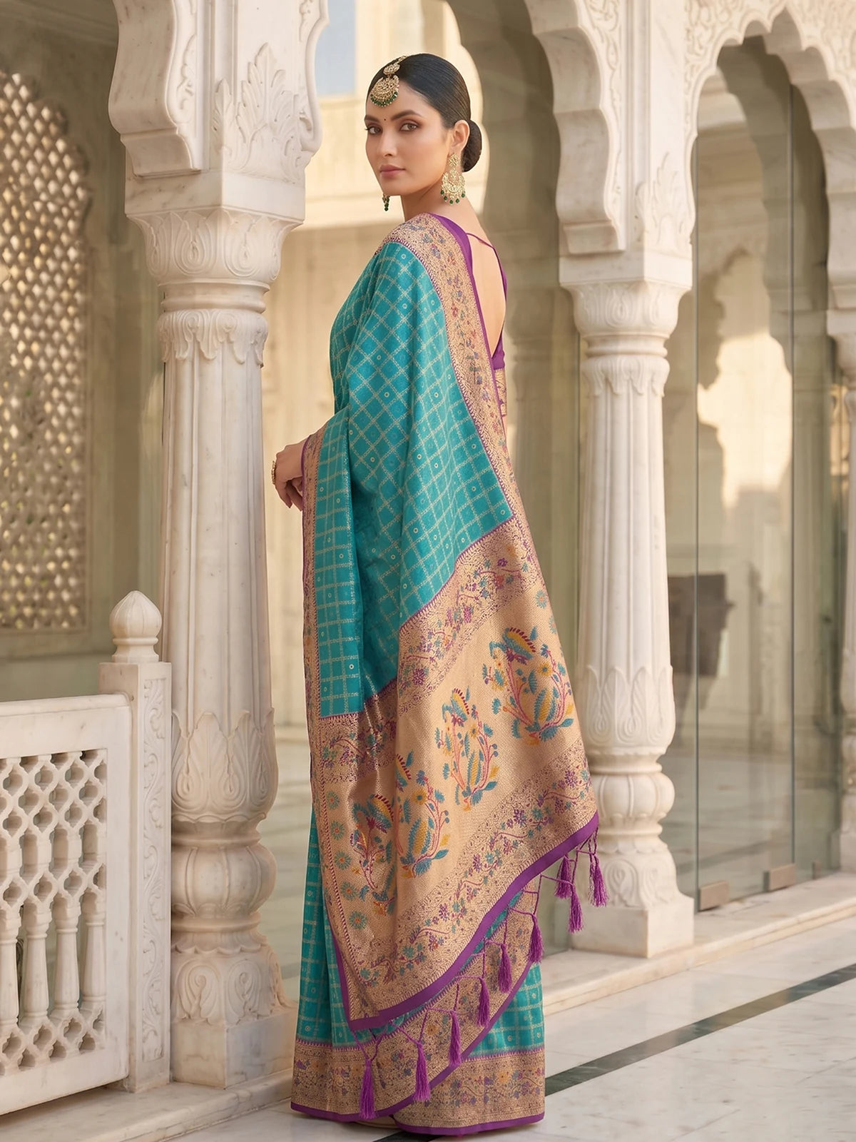 Tarani Banarasi silk teal saree side view showcasing floral pallu and woven border