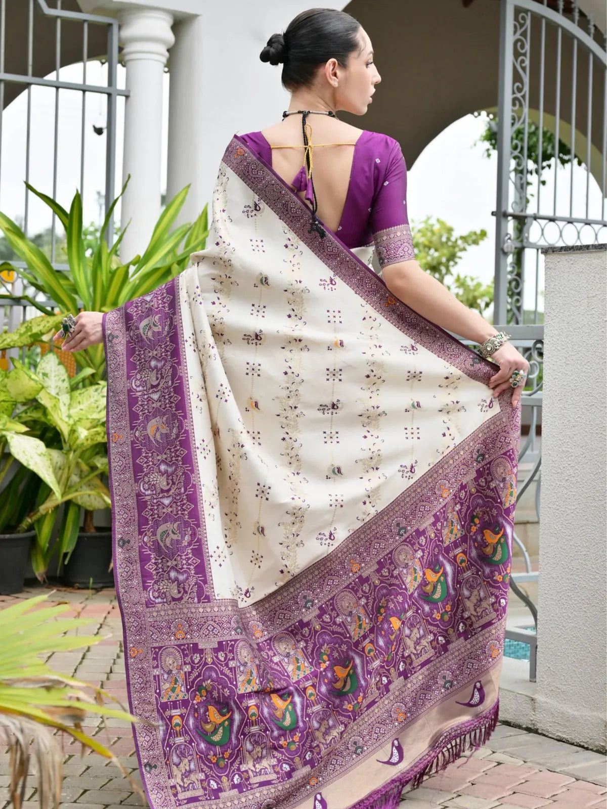 Tarani back view of white and purple saree with tassel pallu drape and contrast blouse with deep neckline