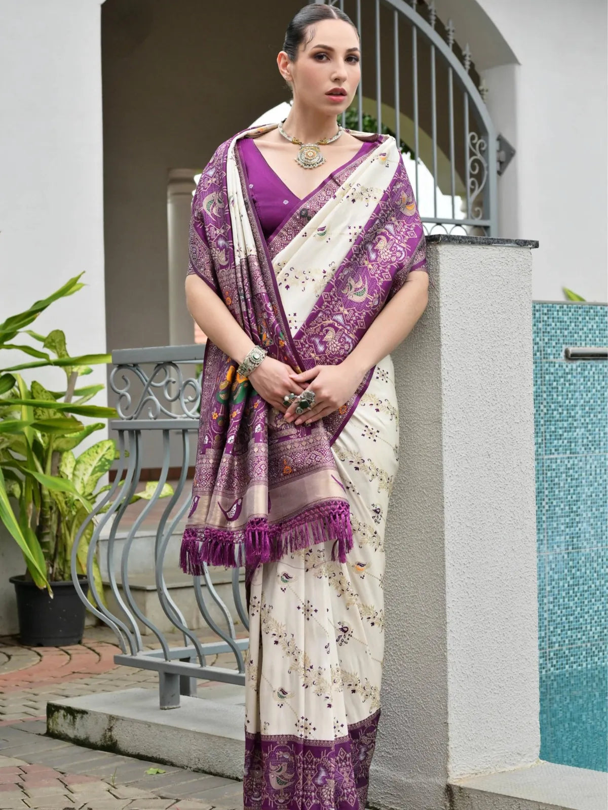 Tarani elegant white saree with purple woven pallu and zari detailing worn fully draped in garden setting