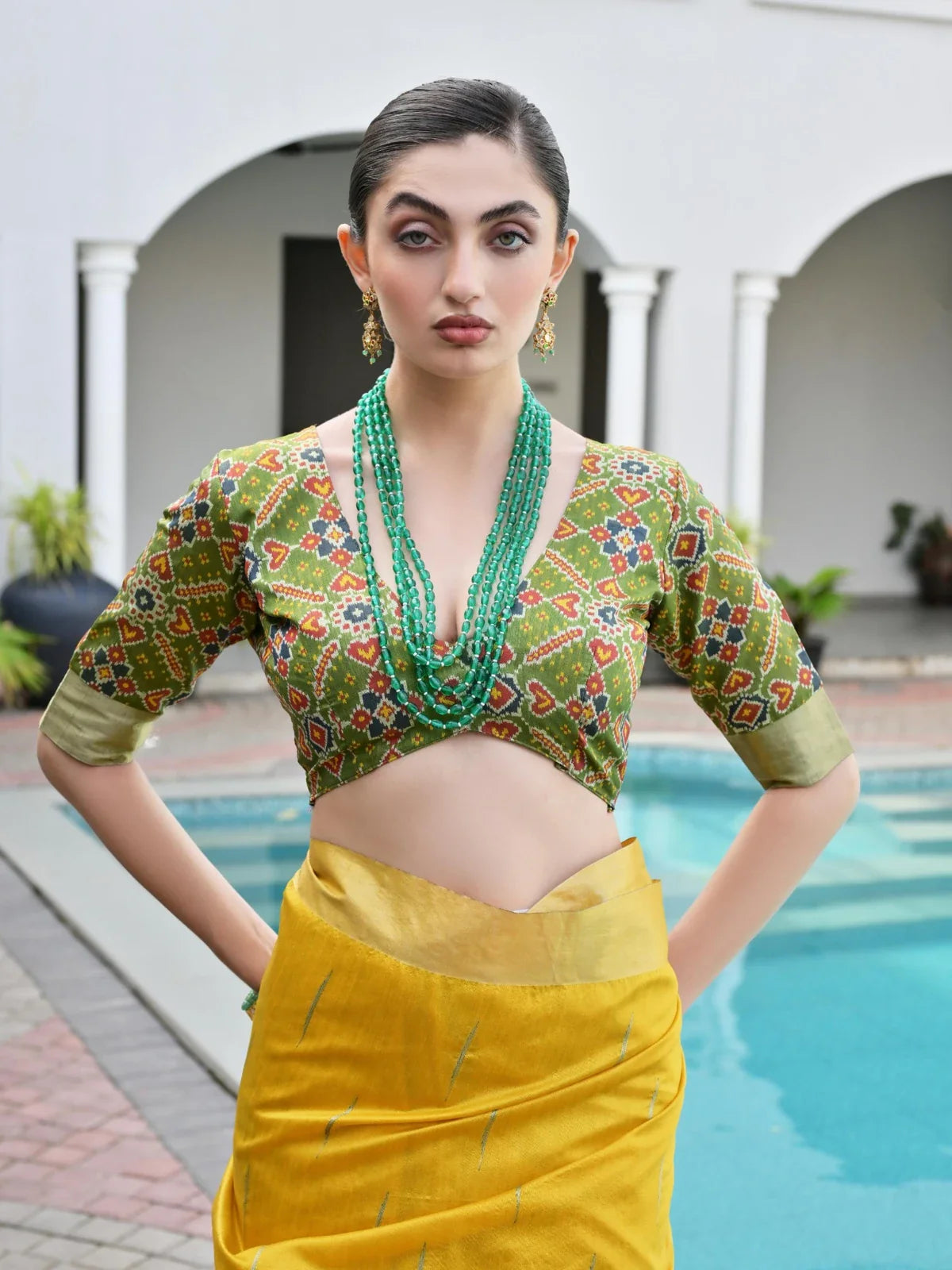 Tarani designer blouse closeup with green ikkat weave and elegant deep-cut back design