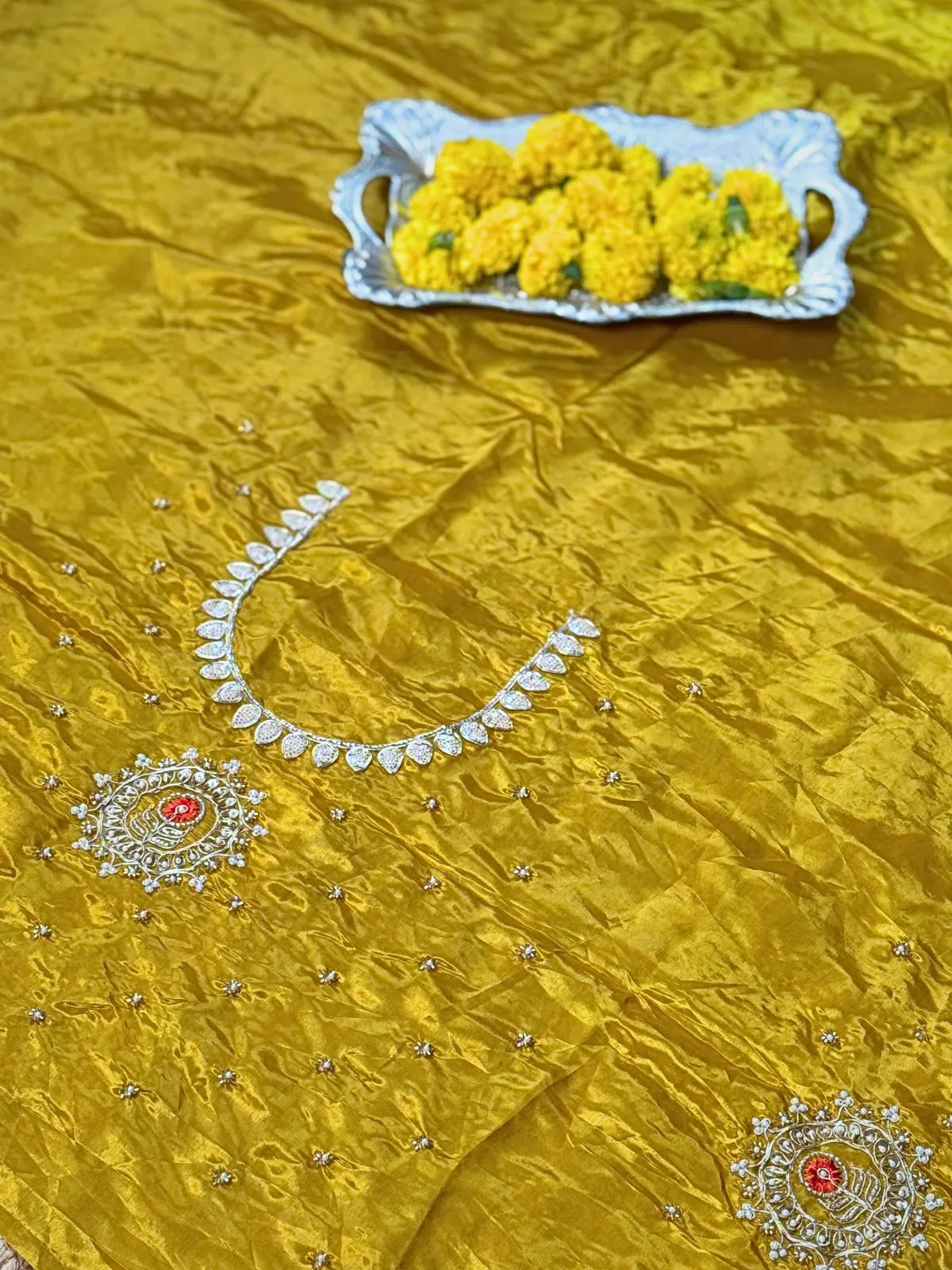 Tarani yellow silk saree blouse close-up with zari work and floral embroidery