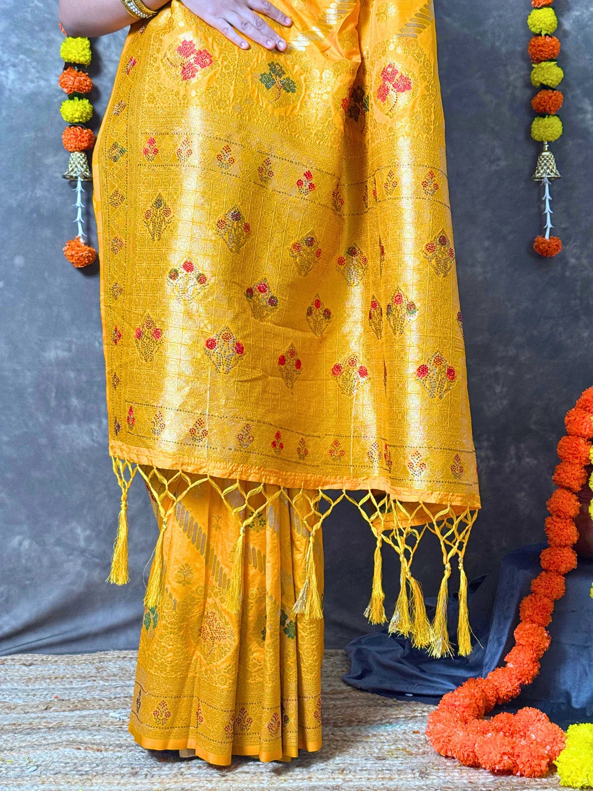 Tarani yellow silk saree pallu view with golden zari design and tassels
