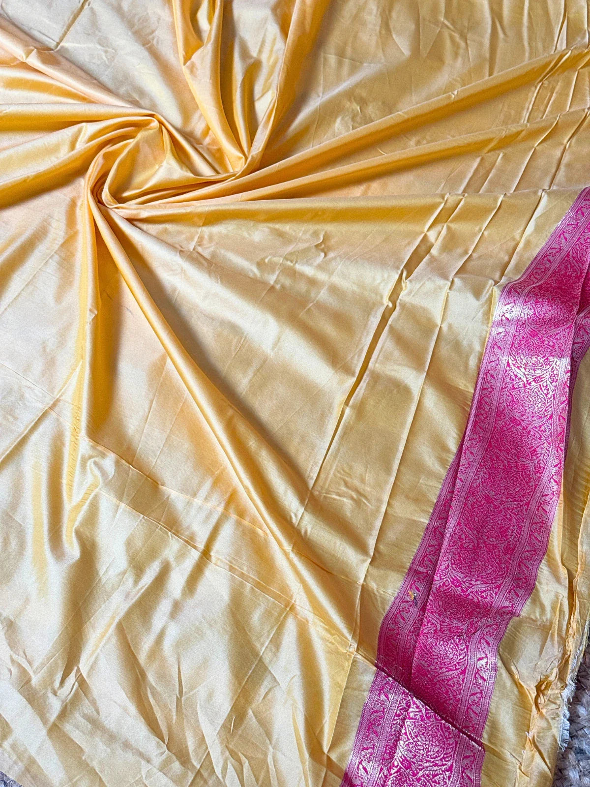 Tarani silk saree yellow blouse fabric with pink border close-up view