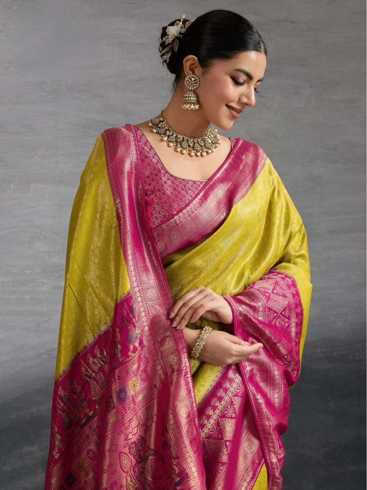 Tarani yellow silk saree upper body view with pink woven border and jewellery styling