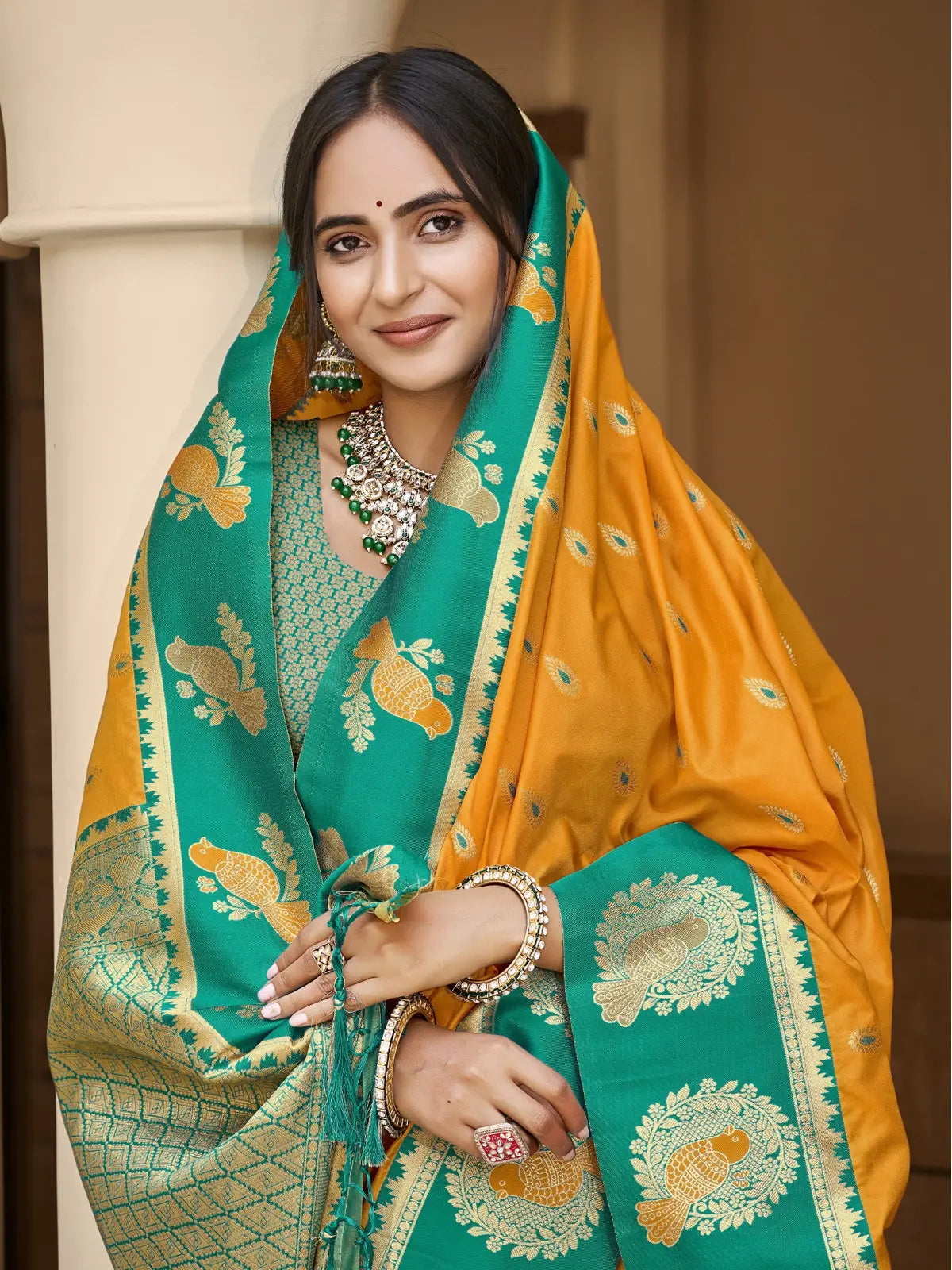 Tarani premium yellow silk saree with contrast blouse and jewelry in upper body view for festive look