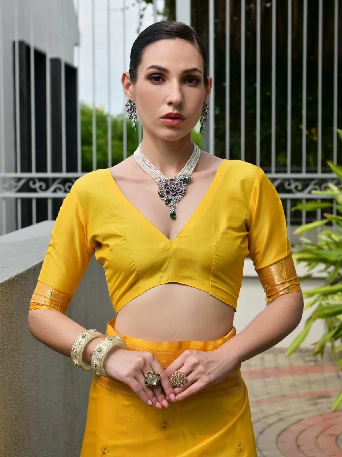 Tarani yellow saree with designer blouse front neckline and jewelry closeup