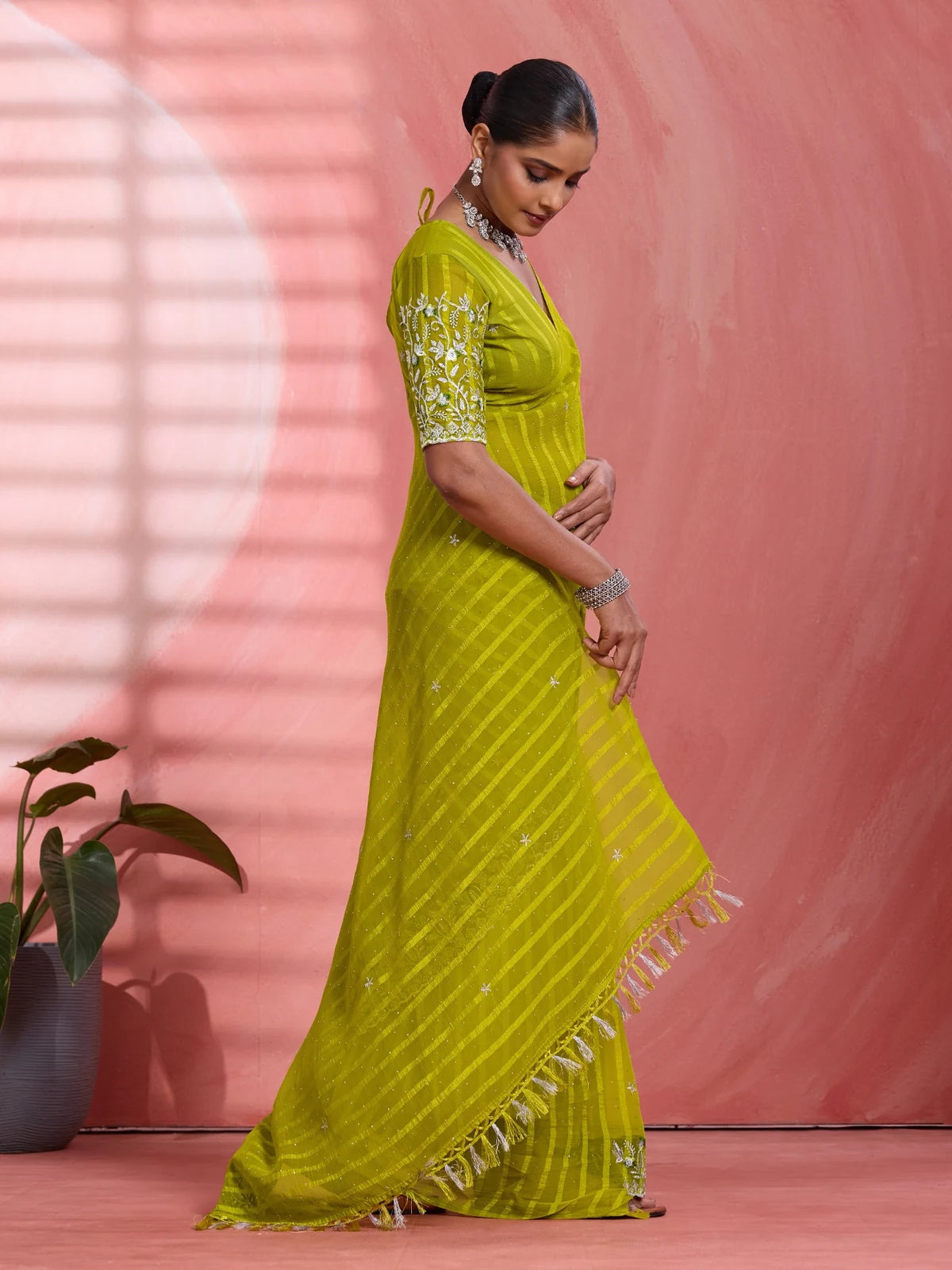 Tarani green chiffon saree side view with elegant striped drape and festive styling