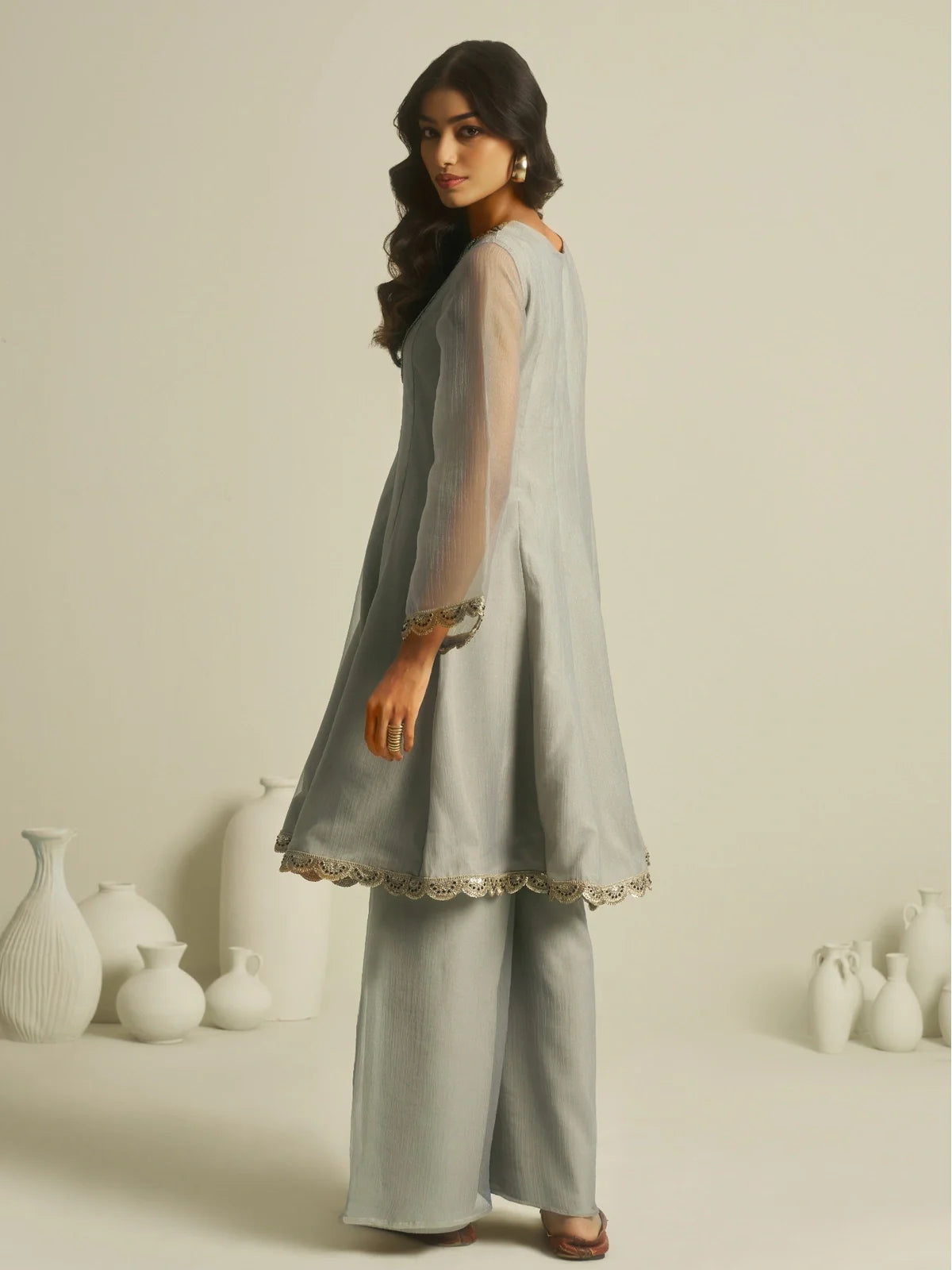 Tarani back view of grey tissue dress showing soft flare and elegant finish