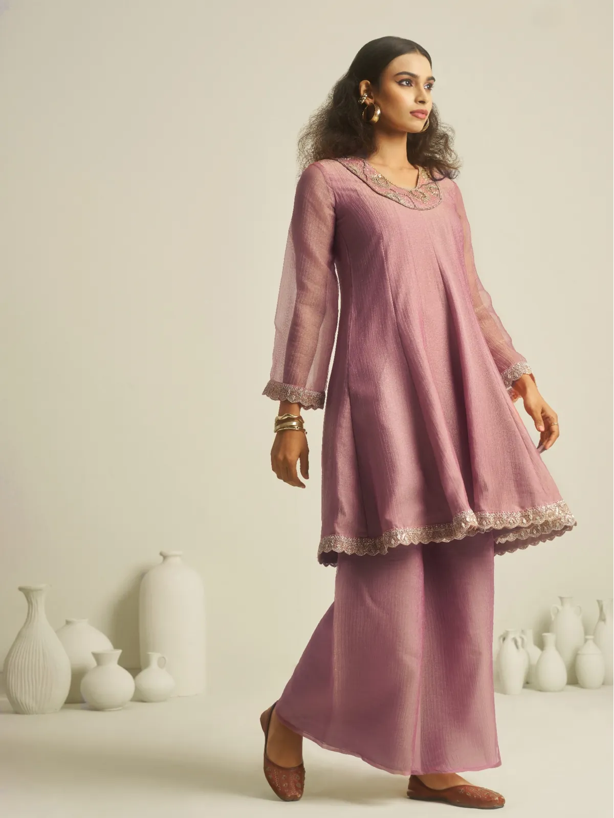 Side profile of Tarani lavender peplum dress with flared palazzo and detailing