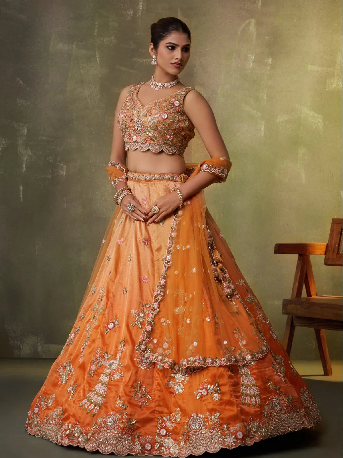 Tarani front view of orange lehenga with floral embroidery and flare