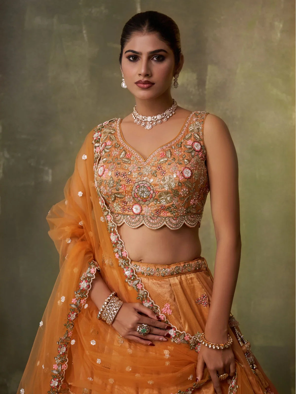Tarani closeup view of blouse and neckline of tissue orange lehenga