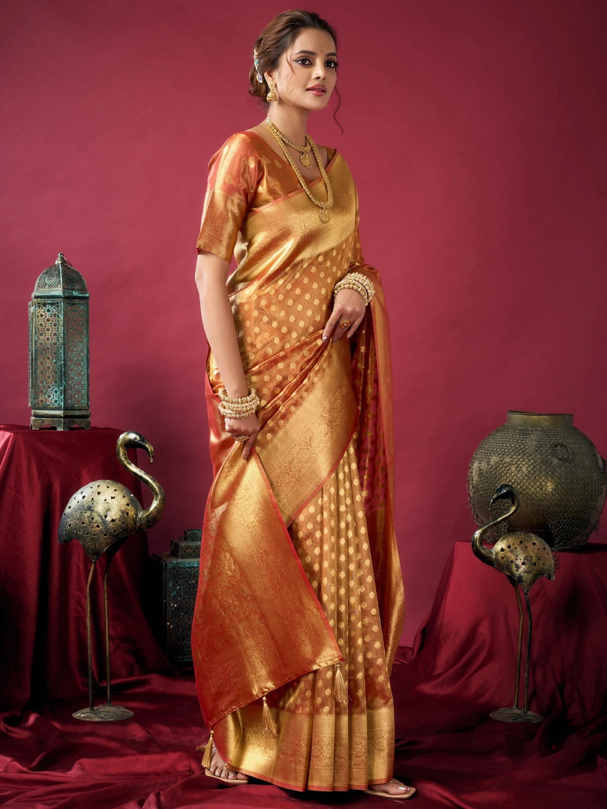 Tarani orange tissue silk saree side view with rich woven border and festive elegance Ameya