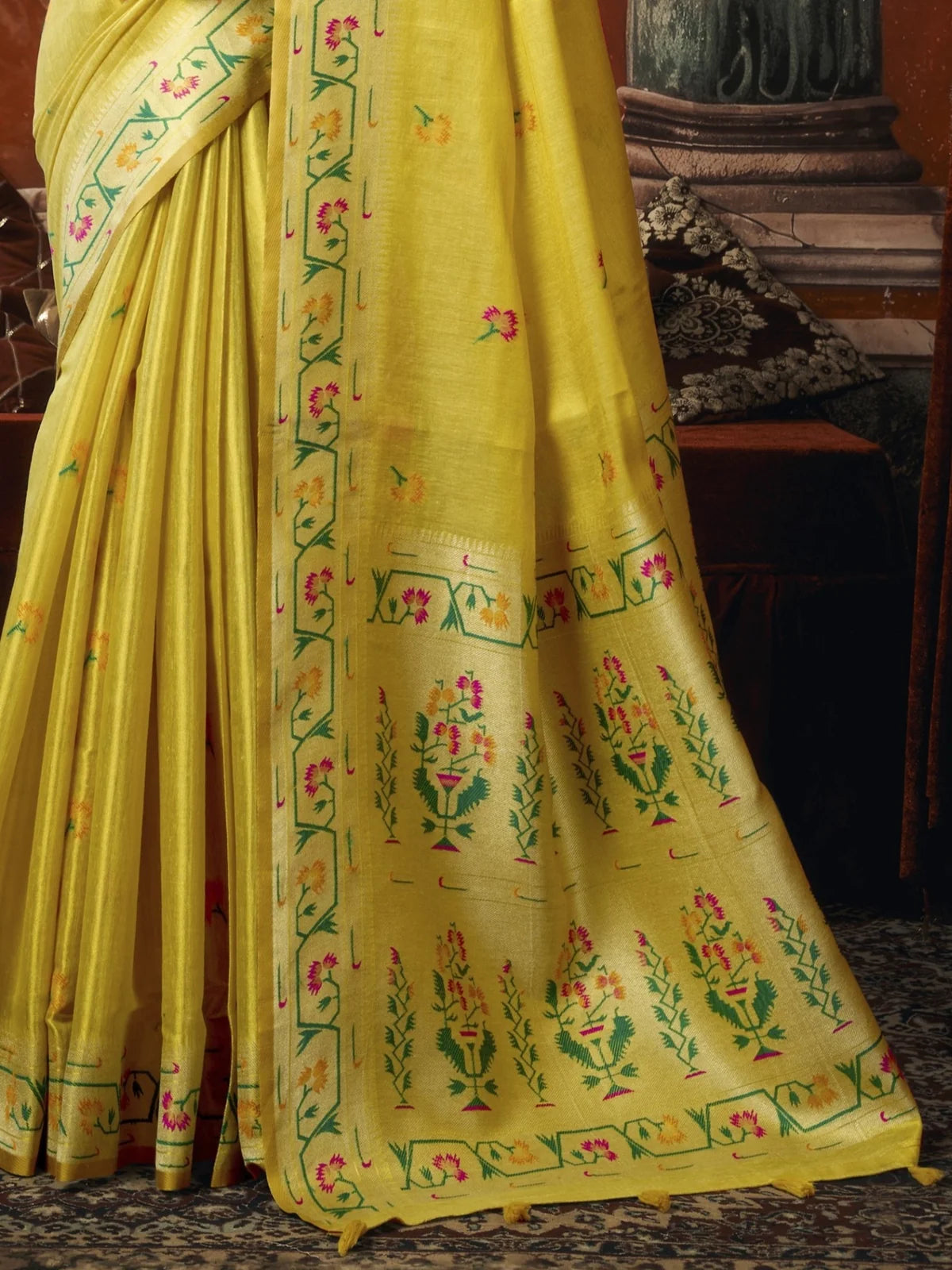Tarani yellow premium tissue silk saree pallu view highlighting woven Paithani floral border and tassels