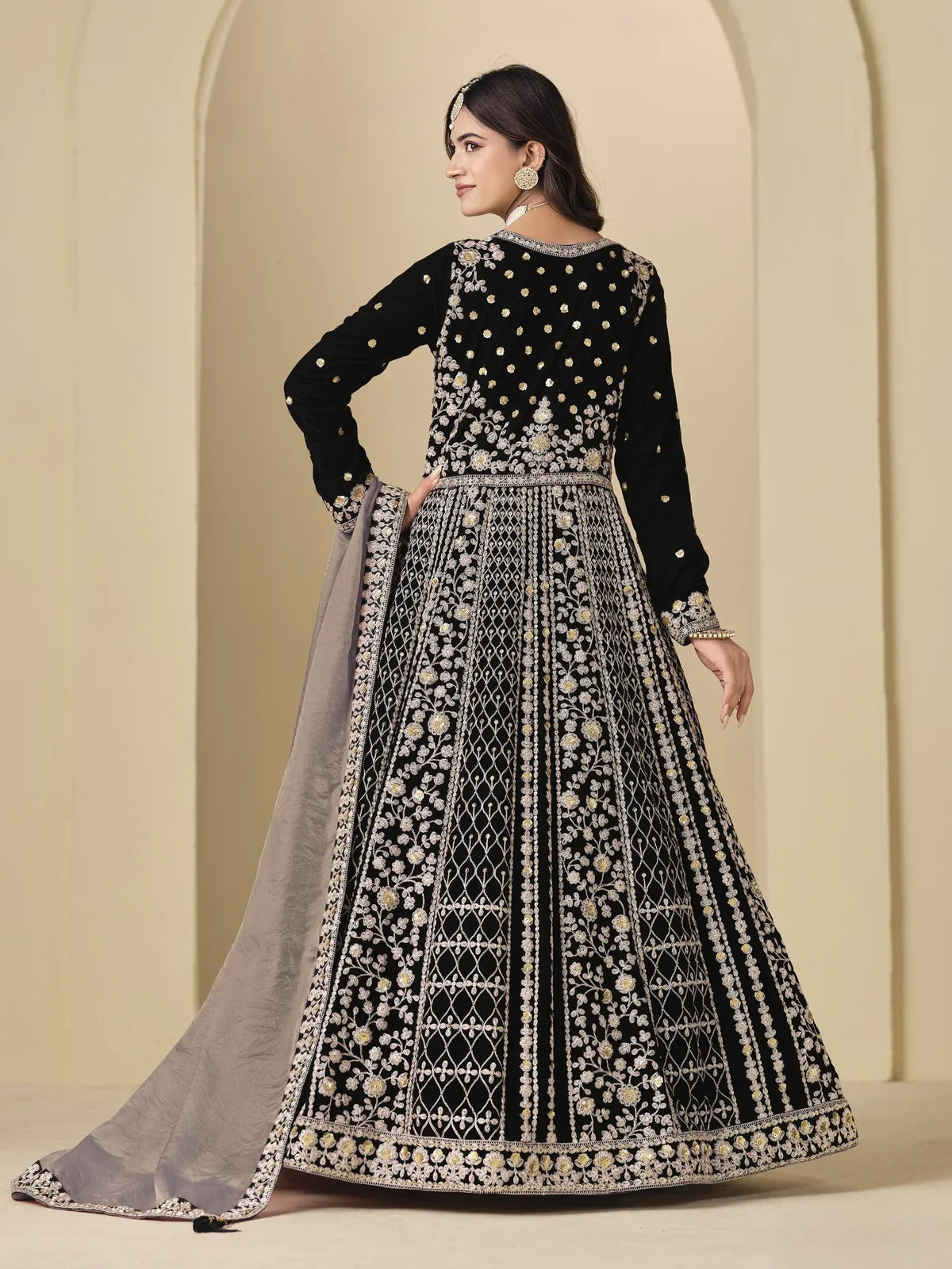 Tarani back view of black embroidered velvet dress with full sleeves and elegant flare