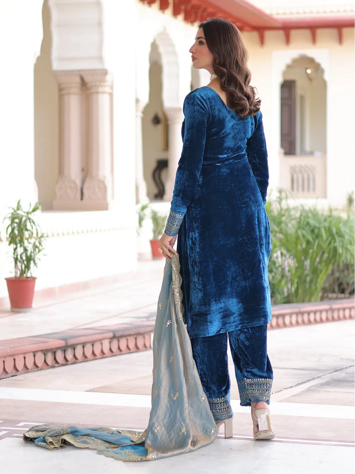 Tarani back view of royal blue velvet party dress with golden detailing and flare