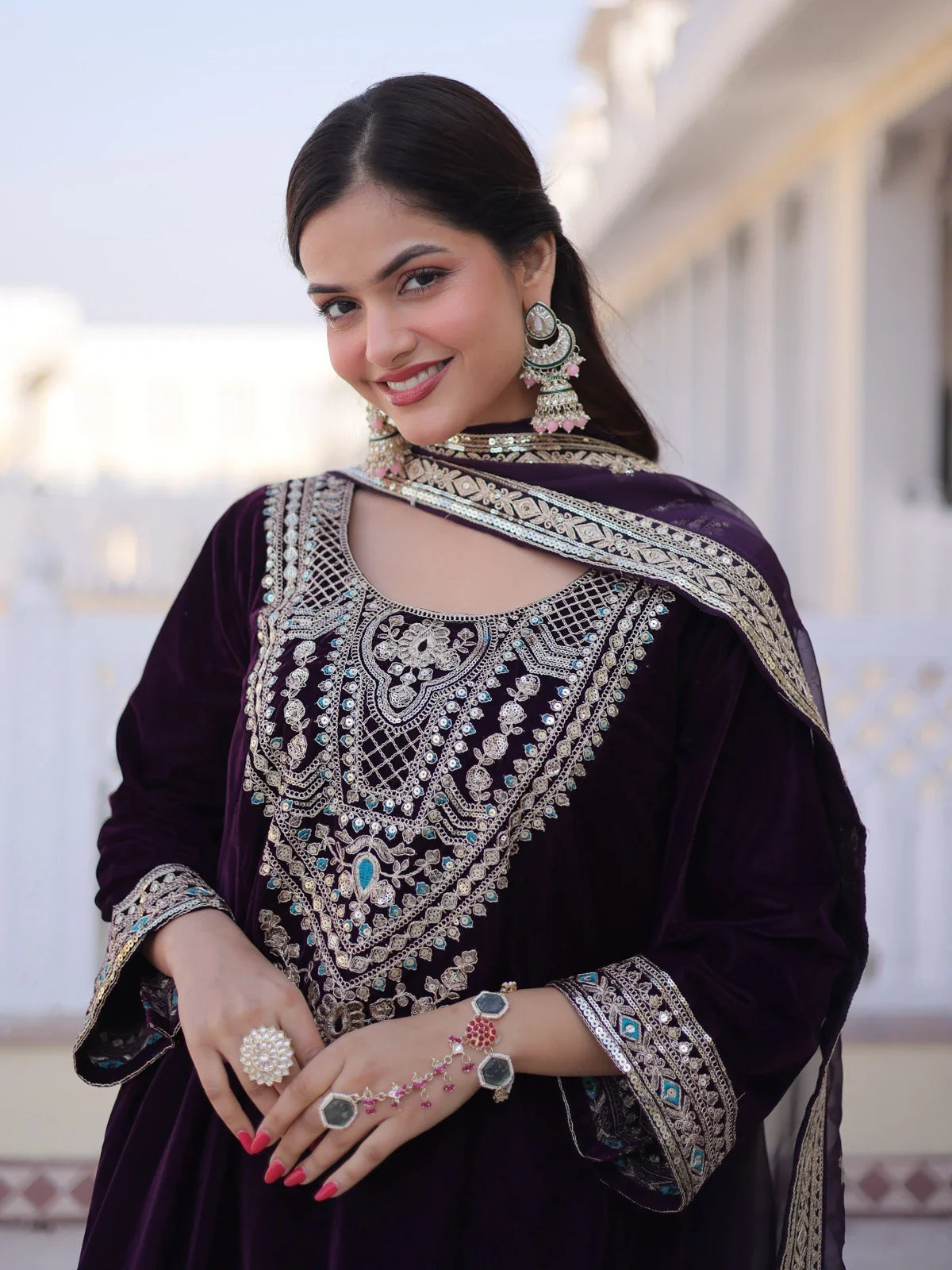 Tarani purple velvet dress with detailed neckline and earrings in upper body view