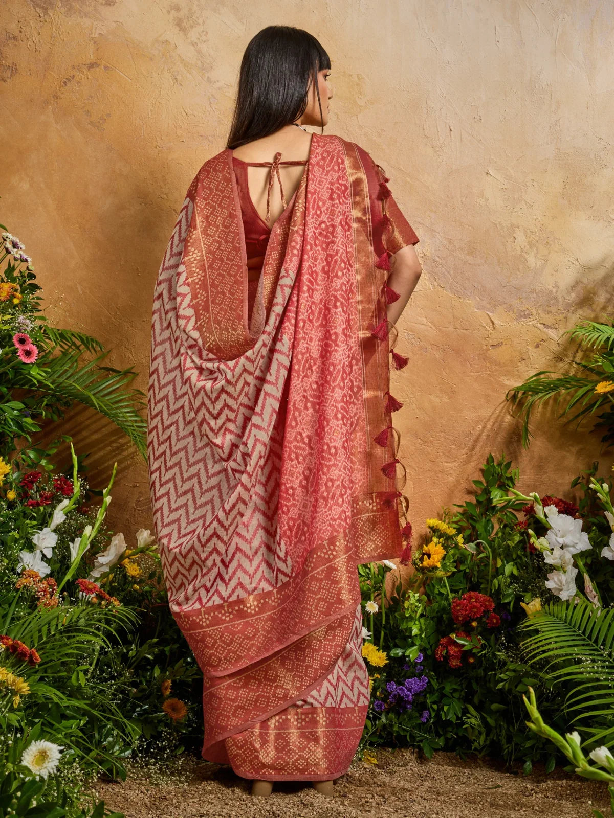 Tarani back view showing open back blouse design and full drape of Patola saree in maroon