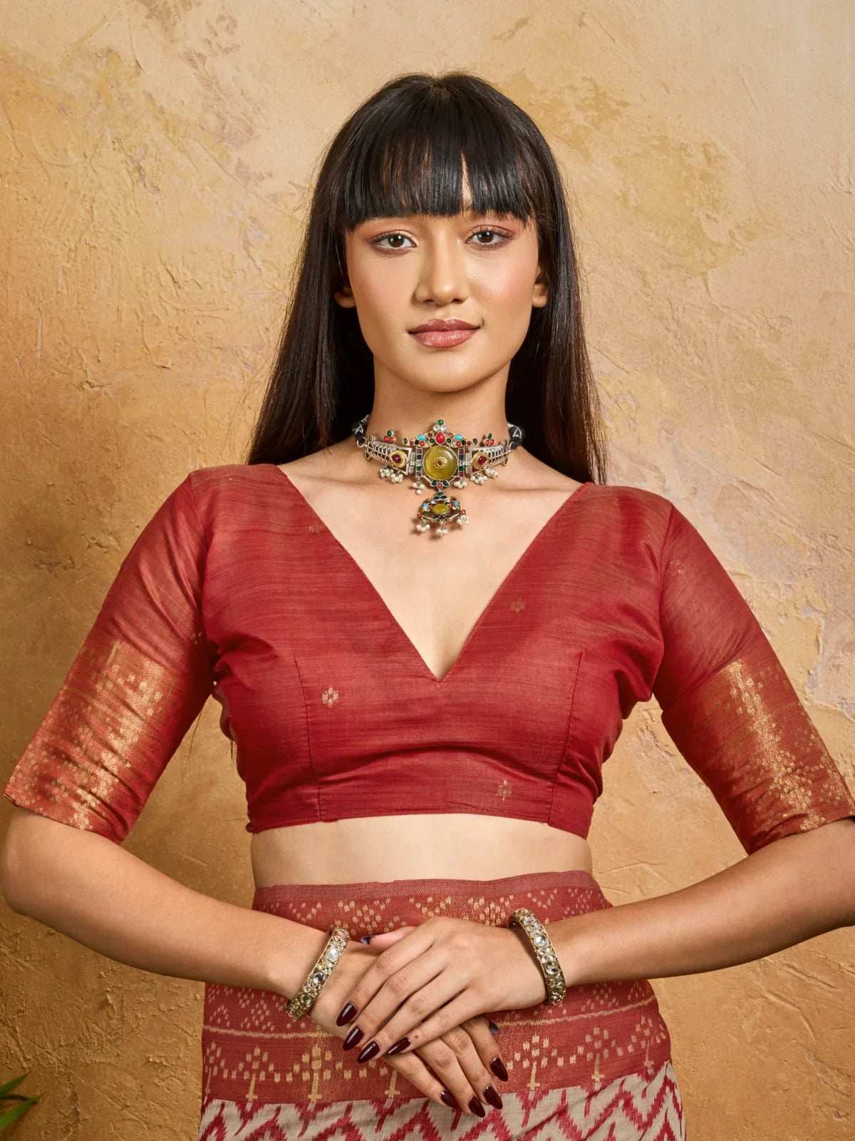 Tarani blouse close-up showing deep V-neck maroon handloom fabric with zari sleeve detailing